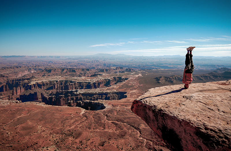Picture of Joel Eggimann who does a head stand in front of the Grand Canyon.